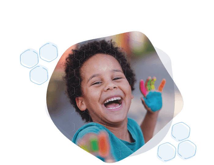 Boys-with-painted-hands-1 opt Young male student with colorfully painted hands laughing.